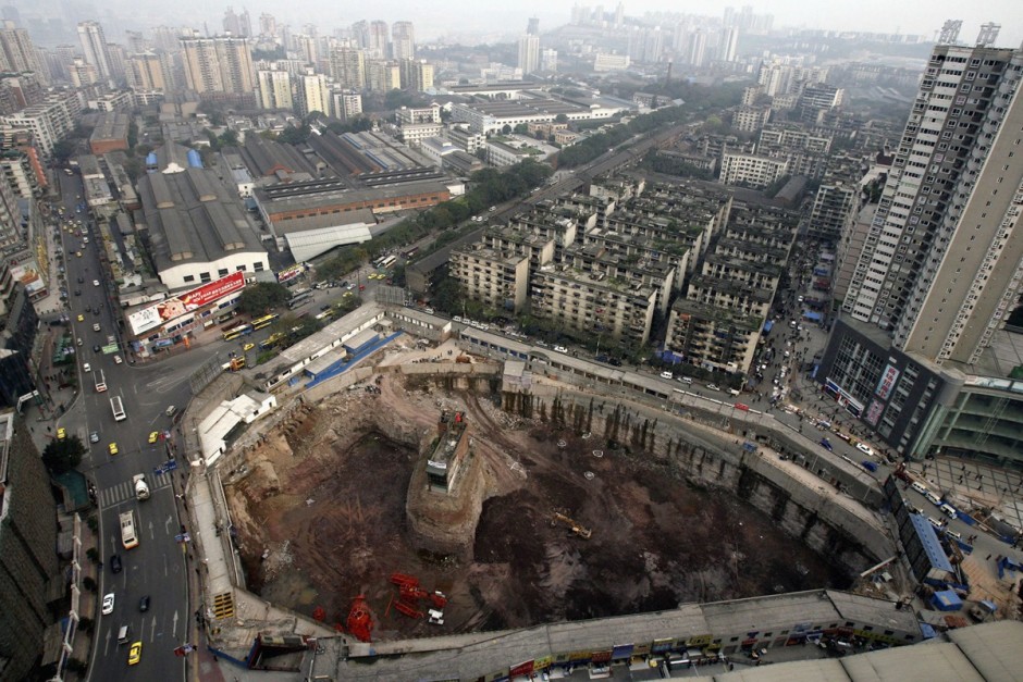 © China Photos/Getty Images - un bâtiment sur un petit îlot de terre en plein milieu d'un chantier à Chongqing Municipality