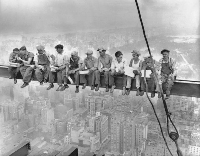 29 Sep 1932 --- Construction workers eat their lunches atop a steel beam 800 feet above ground, at the building site of the RCA Building in Rockefeller Center. --- Image by © Bettmann/CORBIS
