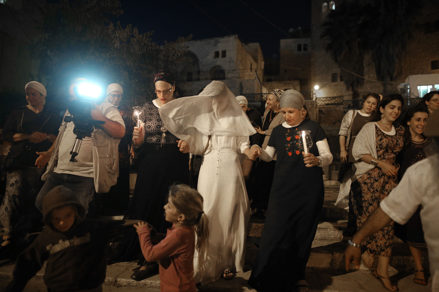© / Menahem Kahana - AFP PHOTO - Photo éditée par Marina Passos - Cette photo représente une jeune mariée israélienne, Yael Levi, accompagnée de ses amis et ses proches vers la place près de la "Cave des Patriarches", aussi connue sous le nom de la Mosquée Ibrahimi et lieu saint des deux communautés juives et musulmanes, lors de son mariage (22 septembre 2016).